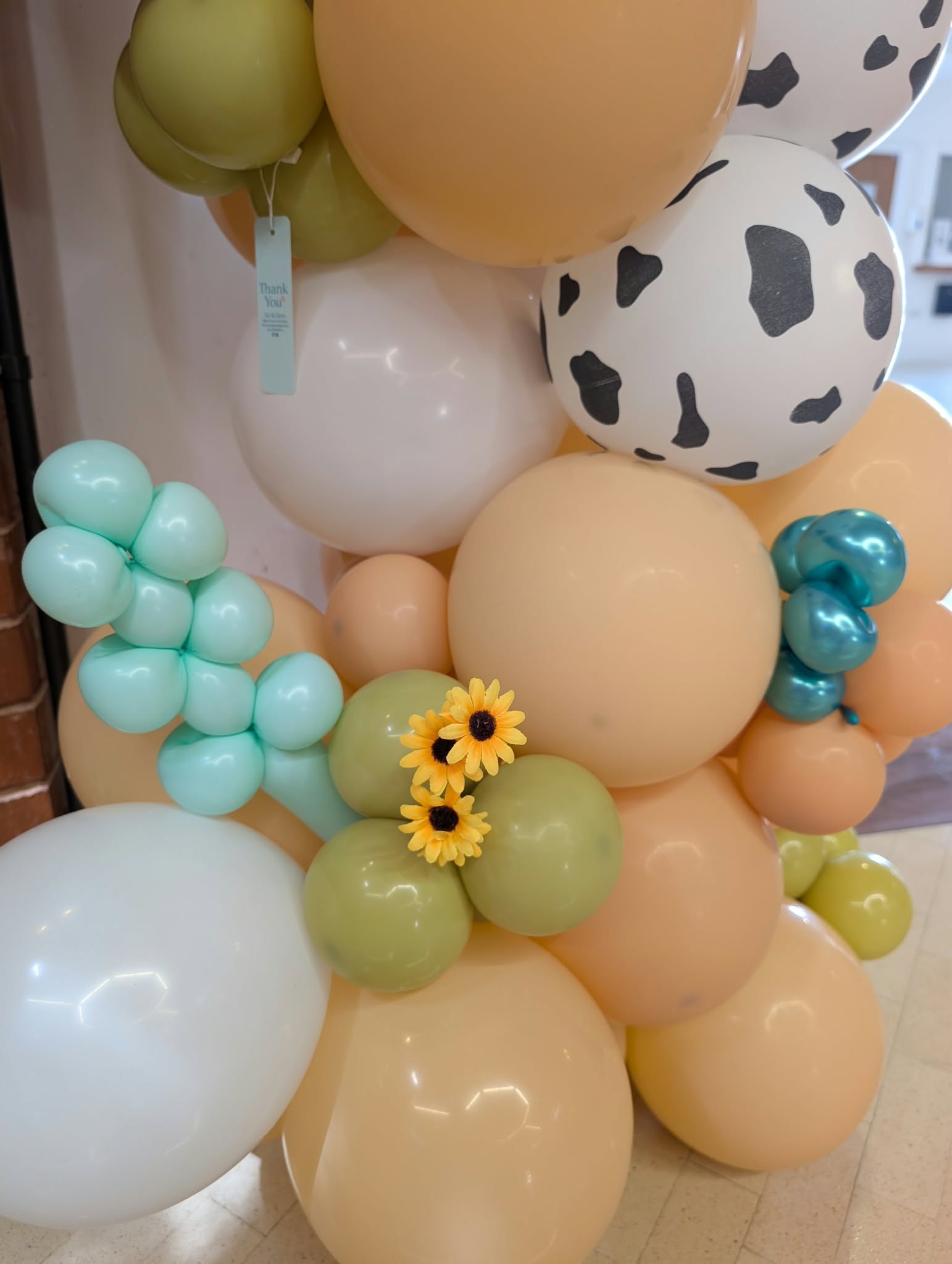 Air & Glow farm themed balloon garland with cow print and sunflowers
